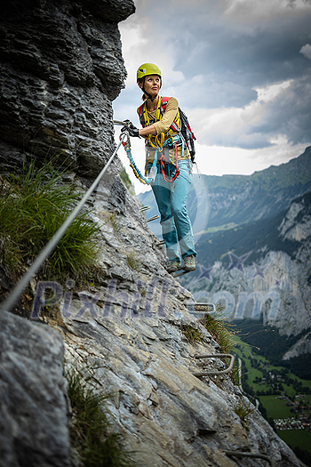 Young, male climber on a via ferrata route - climbing on a rock in Swiss Alps Young, male climber on a via ferrata route - climbing on a rock in Swiss Alps