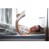 Pretty, middle-aged woman reading a book before sleep in bed