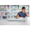 Students in a library - handsome student reading a book for his class in a bright modern library