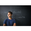 Students in a classroom - handsome student solving a math problem on a blackboard during math class