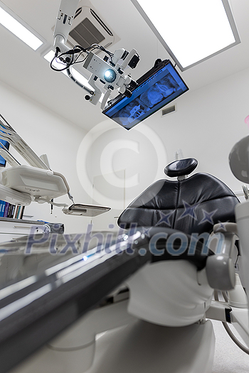 Dental treatment clinic interior with modern patient chair and a TV above Dental treatment clinic interior with modern patient chair and a TV above