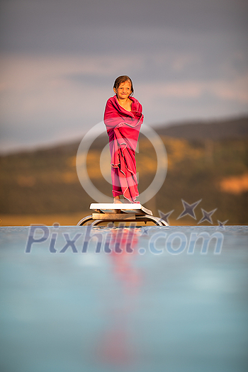 Little girl on a pool's edge, learning to swim and dive. Swimming with kids. Healthy sport activity for children. Sun protection. Water fun. Little girl on a pool's edge, learning to swim and dive. Swimming with kids. Healthy sport activity for children. Sun protection. Water fun.