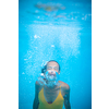 Gorgeous young woman in a pool, jumping and diving underwater, having fun