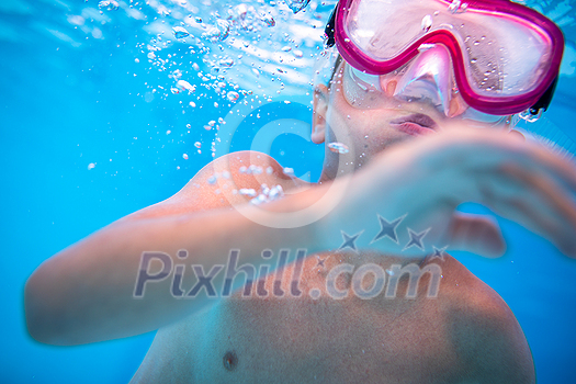 Cute little boy in a swimming pool, diving, swimming underwater, having fun Cute little boy in a swimming pool, diving, swimming underwater, having fun