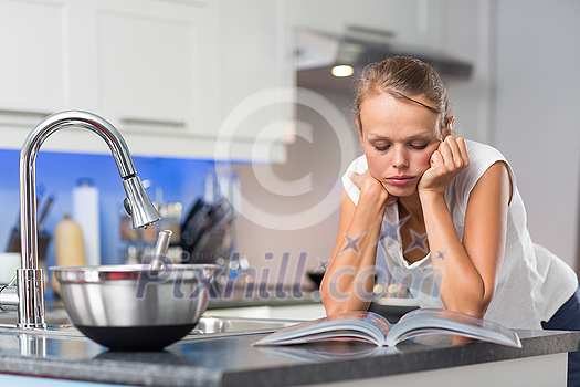 Pretty, young woman in her modern, clean and bright kitchen, fixing lunch (color toned imagey; shallow DOF) Pretty, young woman in her modern, clean and bright kitchen, fixing lunch (color toned imagey; shallow DOF)