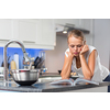 Pretty, young woman in her modern, clean and bright kitchen, fixing lunch (color toned imagey; shallow DOF)