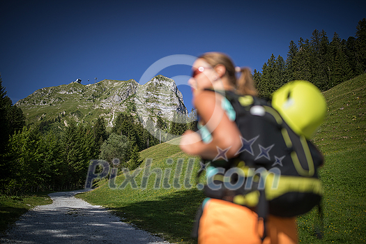 Pretty, female climber on a via ferrata - climbing on a rock in Swiss Alps - Approach phase Pretty, female climber on a via ferrata - climbing on a rock in Swiss Alps - Approach phase