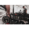 Struggling with age. Confident senior man exercising with dumbbells in the health club. Selective focus. High-quality photo