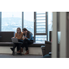 Two businesswomen sitting in a modern coworking space on a break from work and relaxing using a laptop. Selective focus. High-quality photo