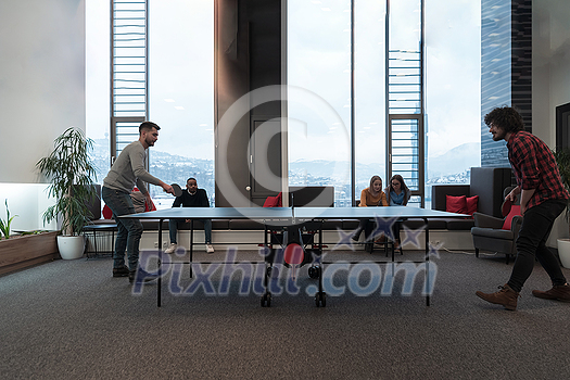 Two young start-up businesses man playing table tennis at modern creative office space people group have meeting and brainstorming in background. High-quality photo Two young start-up businesses man playing table tennis at modern creative office space people group have meeting and brainstorming in background. High-quality photo