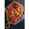 Sliced Homemade tasty pizza with bacon, egg, cheese, tomatoes and basil  on dark background. Top view.