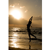 Girl jumping on sunrise at the beach