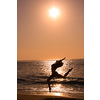 Female jumping at beach on sunrise