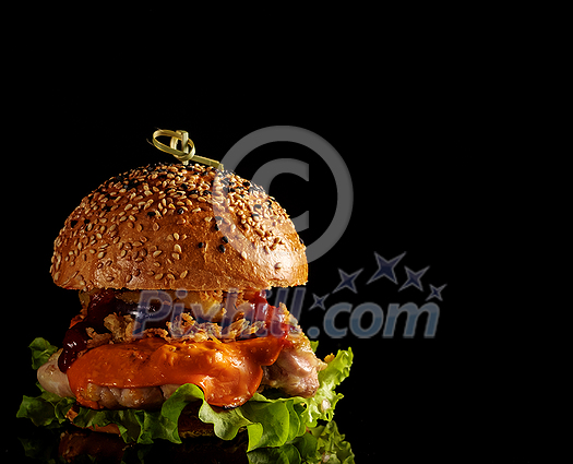 Tasty homemade grilled chicken burger with lettuce, cheese, ananas and red onion served on a black table, with copyspace Tasty homemade grilled chicken burger with lettuce, cheese, ananas and red onion served on a black table, with copyspace