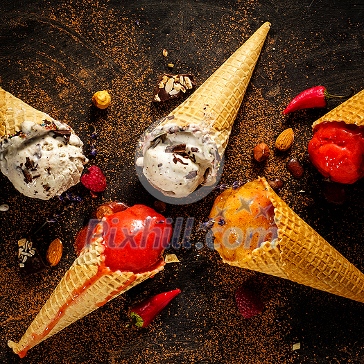 Different varieties of ice cream in waffle cones on the table, top view. Different varieties of ice cream in waffle cones on the table, top view.