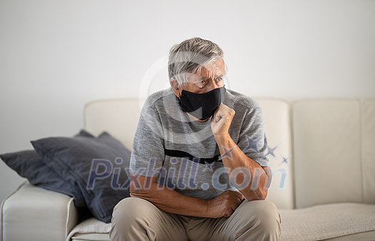 Senior man wearing a facemask during coronavirus and flu outbreak. Virus and illness protection, home quarantine. COVID-19 concept Senior man wearing a facemask during coronavirus and flu outbreak. Virus and illness protection, home quarantine. COVID-19 concept