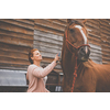 Pretty, young, redhead woman with her lovely horse, during her favorite leisure