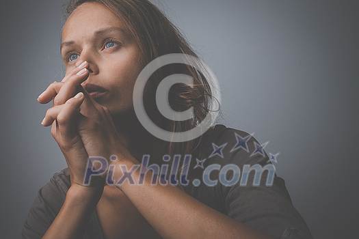 Depressed, anxious young woman facing harsh life situation, suffering from mental disorders, illness. Praying for things to get better.