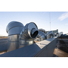 External unit of commercial air conditioning and ventilation system installed on industrial building roof. Exhaust vent on flat factory rooftop
