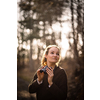 Young woman with binoculars outdoors on fall day. Enjoying the outdoors.
