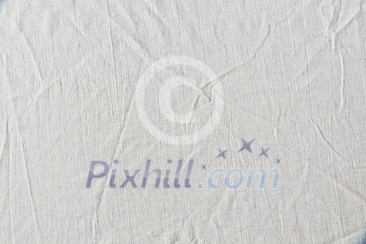 White crumpled linen cloth background. Eco-friendly material used for tablecloth and home textile. White crumpled linen cloth background. Eco-friendly material used for tablecloth and home textile.