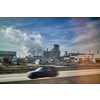 Creative landscape with large power plant on the background of blue cloudy sky and blurred car on a forefront in Budapest, Hungary.