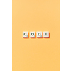 Code word formed of scrabble blocks on yellow background. Creative template with copy space.