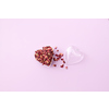 Dried red rose petals in open transparent heart-shaped pendant on toned background with space for text. Creative Valentine's day card design.