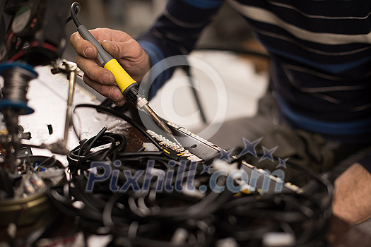 Industrial worker man soldering cables of manufacturing equipment in a factory. Selective focus. High quality photo Industrial worker man soldering cables of manufacturing equipment in a factory. Selective focus. High quality photo