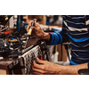 Industrial worker man soldering cables of manufacturing equipment in a factory. Selective focus. High-quality photo