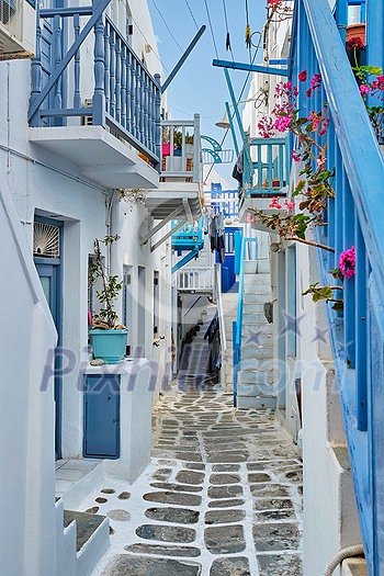 Picturesque scenic narrow Greek streets with traditional whitewashed houses with blue doors windows of Mykonos town in famous tourist attraction Mykonos island, Greece