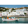 Greek fishing boat in clear sea water in port of Mykonos. Chora town, Mykonos, Greece