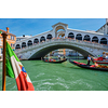 Italian maritime flag with Rialto bridge with boats and gondolas in the bacground. Grand Canal, Venice, Italy