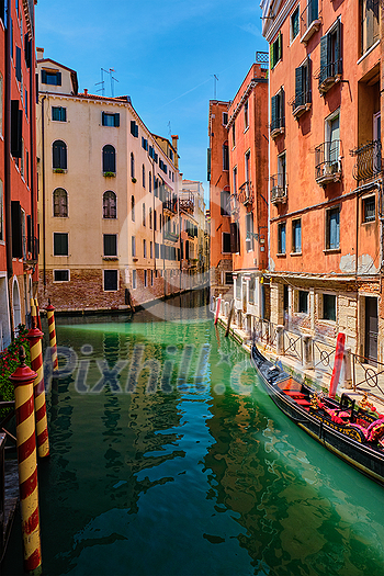 Narrow canal between colorful old houses with gondola boat in Venice, Italy Narrow canal between colorful old houses with gondola boat in Venice, Italy