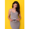 smiling pregnant woman showing ultrasound picture of her unborn baby isolated on yellow background
