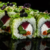 Close-up of traditional japanese sushi on a dark background with reflection. Roll with tuna and greens