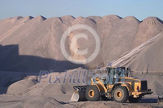 Caterpillar in front of a mountain of sand Caterpillar in front of a mountain of sand